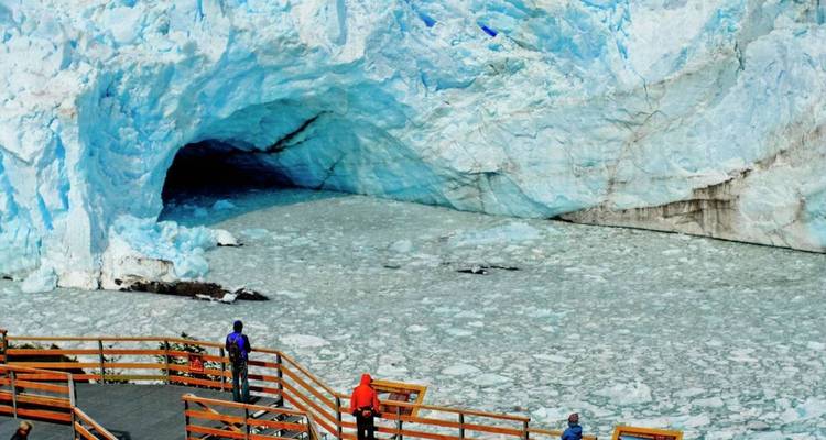 Blick auf einen Gletscher mit Menschen auf einer Plattform.
