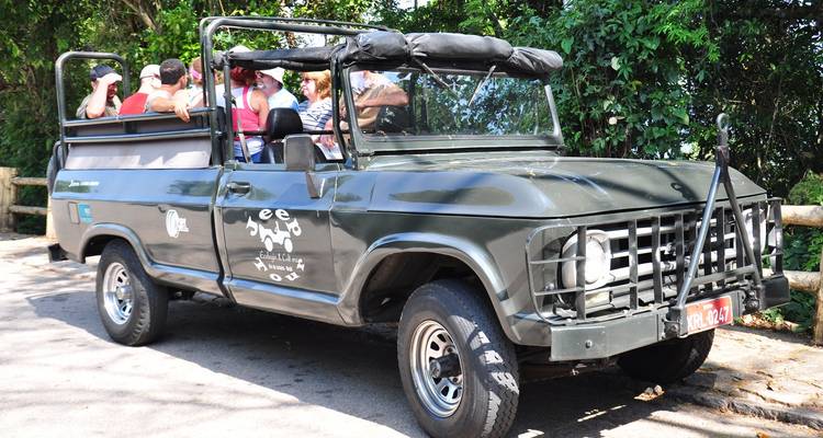 Touristes dans un véhicule de safari ouvert.