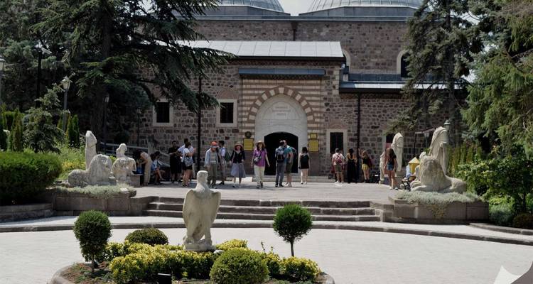 Des gens debout devant un bâtiment historique avec des arches.