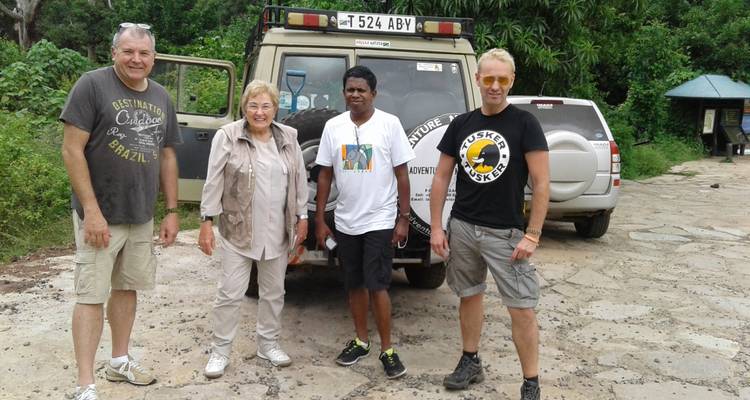 Quatre personnes posant devant un véhicule de safari.