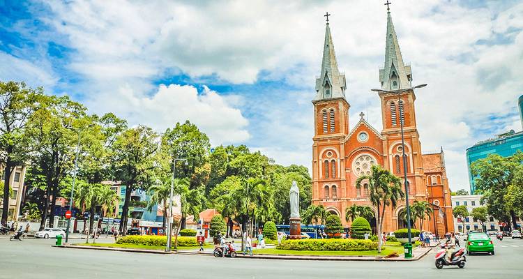 Eine große Kathedrale mit Zwillingstürmen in einem belebten Stadtviertel.