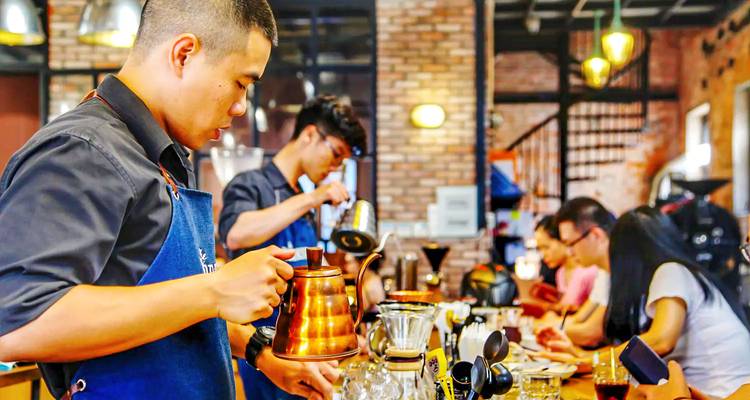Ein lebhaftes Café mit Baristas, die Kaffee zubereiten.