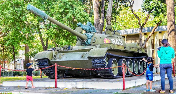 Ein Militärpanzer, der im Freien ausgestellt ist, mit Leuten, die ihn betrachten.