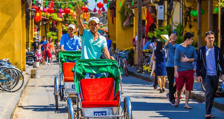 Rikscha-Fahrer winken auf einer lebendigen Straße.