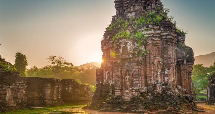 Ancient temple ruins with sun rising behind.
