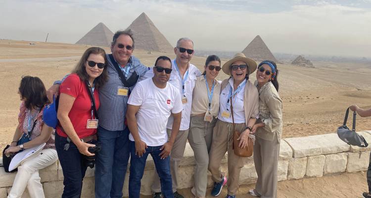 Touristen posieren mit den Pyramiden von Gizeh im Hintergrund.