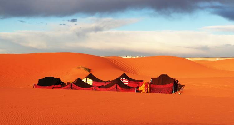 Tiendas de campaña coloridas en medio de las dunas de arena.