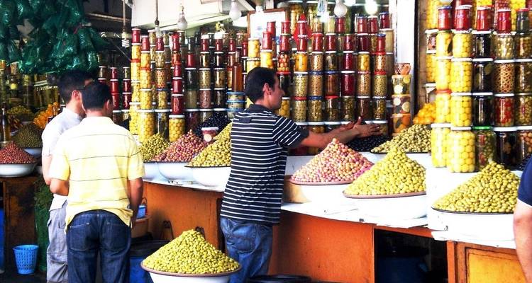 Puesto de mercado con varios productos encurtidos y conservas.