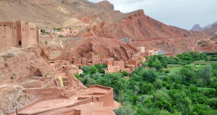 Vista de un pueblo de montaña con edificios de arcilla rojiza.