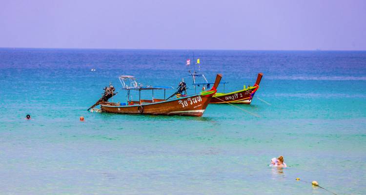 Bateaux à longue queue en mer avec horizon lointain.