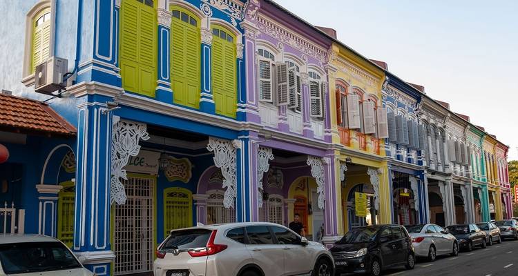 Bunte Kolonialarchitektur auf einer Straße mit geparkten Autos.