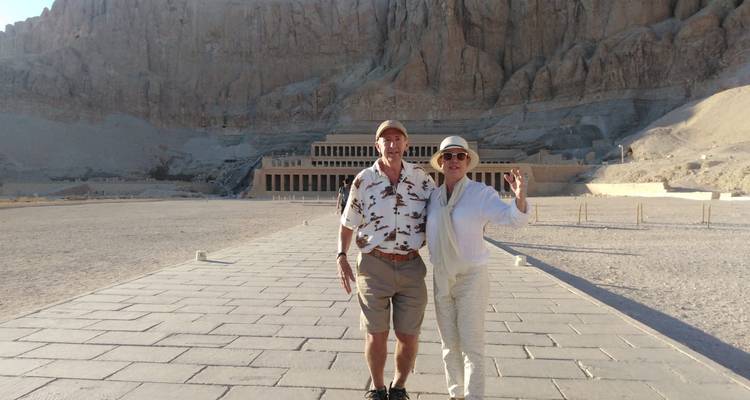 Paar posiert vor einem großen antiken Tempel in der Wüste.