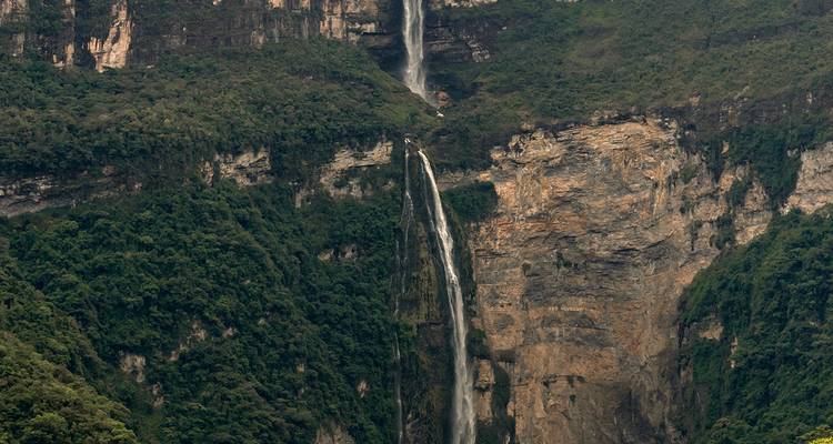 A waterfall cascading down a lush green cliff.