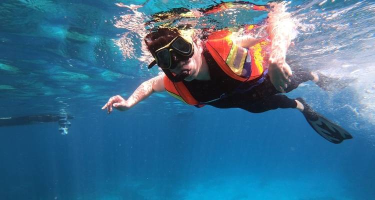 Persoon snorkelt onder water.