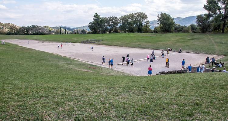 Ancient stadium-like field with people exploring the area.