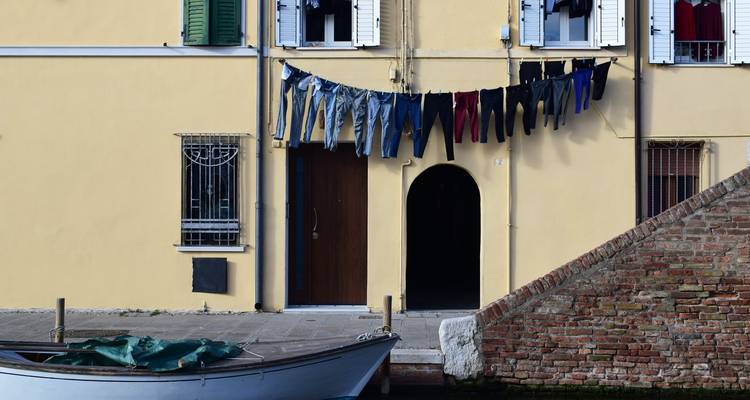 Paire de jeans suspendue à une corde à linge près d'un bateau.