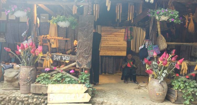 Indoor market stall with fabrics and crafts.