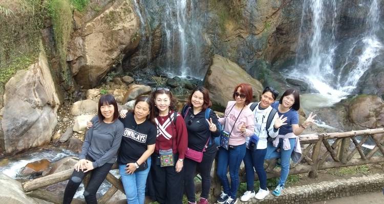 Eine Gruppe von Touristen, die vor einem Wasserfall posiert.