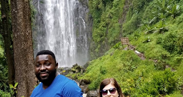 Zwei Menschen stehen vor einem Wasserfall.