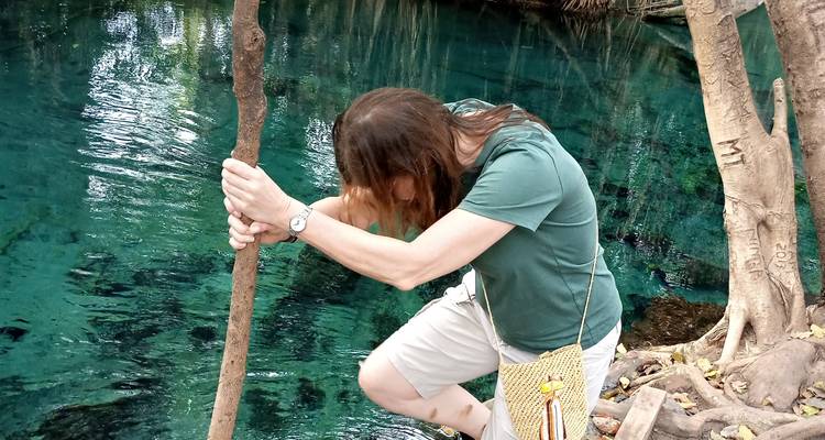 Person, die einen Stock an einem klaren Gewässer hält.