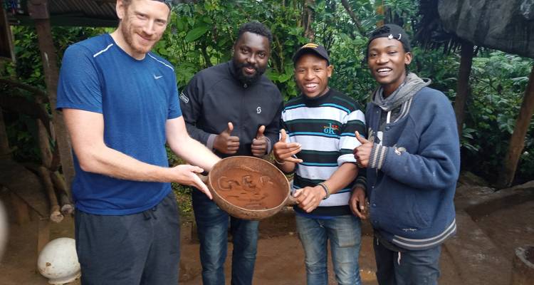 Gruppe von Menschen, die eine Schüssel mit eingeritzten Initialen hält.