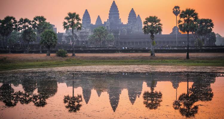 Angkor Wat temple reflected in a pond at sunrise.