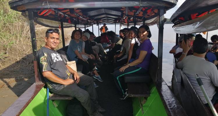 Grupo de personas sentadas en un barco recorriendo un río.