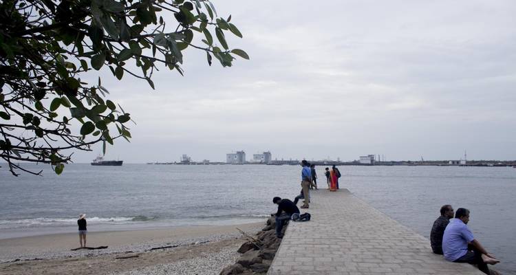 Mensen die ontspannen op een lange pier die zich uitstrekt in de zee.