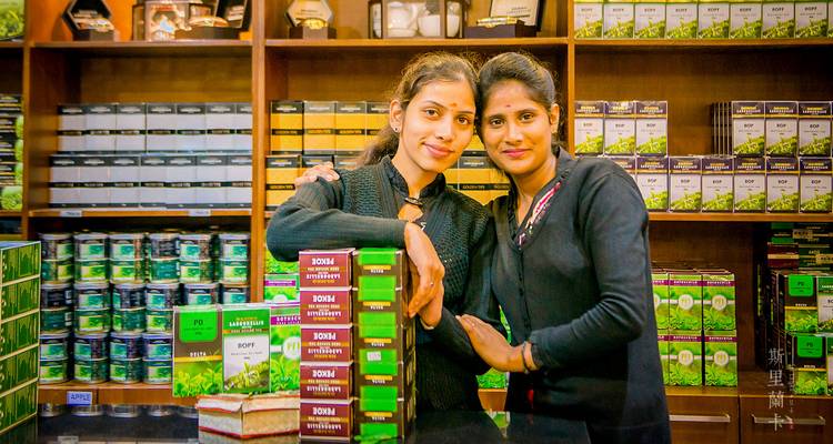 Two people posing in front of a tea shop.