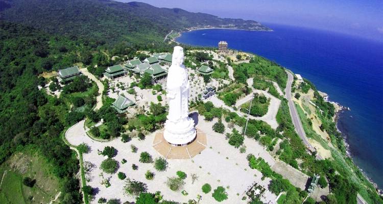 Große Statue mit Blick auf eine Küstenlandschaft.