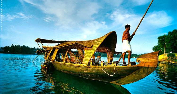 Man op een traditionele houten boot op een rivier.