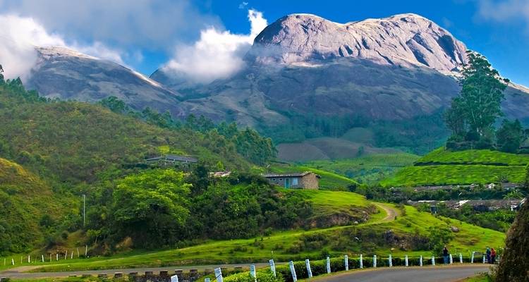 Groene bergen onder een blauwe hemel met wolken.