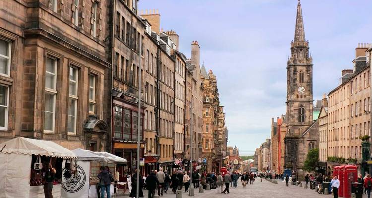 La célèbre Royal Mile à Édimbourg, animée et bordée de bâtiments historiques en pierre et de la tour de la cathédrale Saint-Gilles.