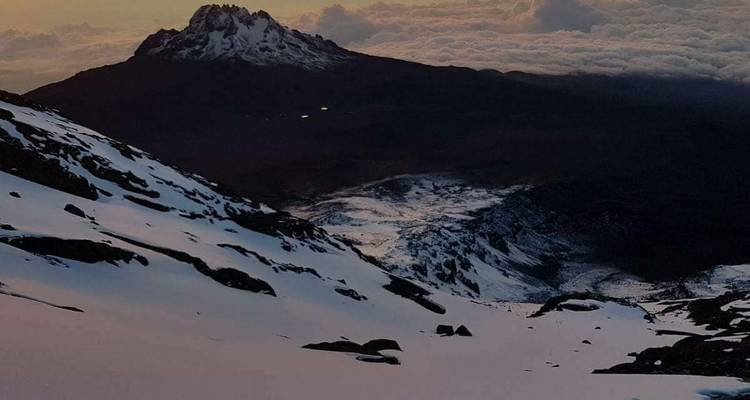 Bergketen bij zonsondergang met sneeuwvlekken.