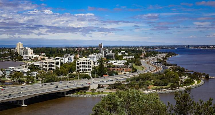 Vue surélevée des banlieues de Perth, de l'autoroute et du front de rivière sous un ciel bleu partiellement nuageux