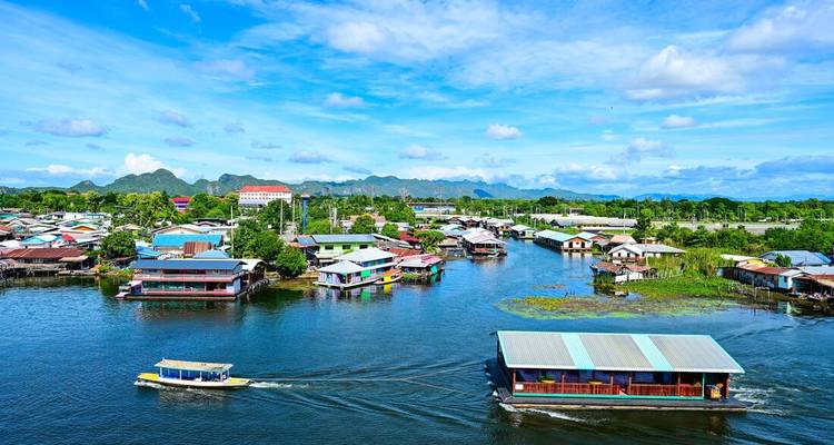 Floating houses along a river with vibrant sky.