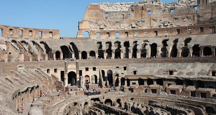Weite Sicht auf das Innere des Kolosseums mit Touristen.