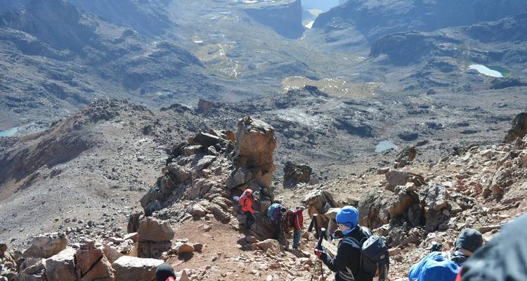 Wanderer, die sich durch felsiges Berggelände bewegen.