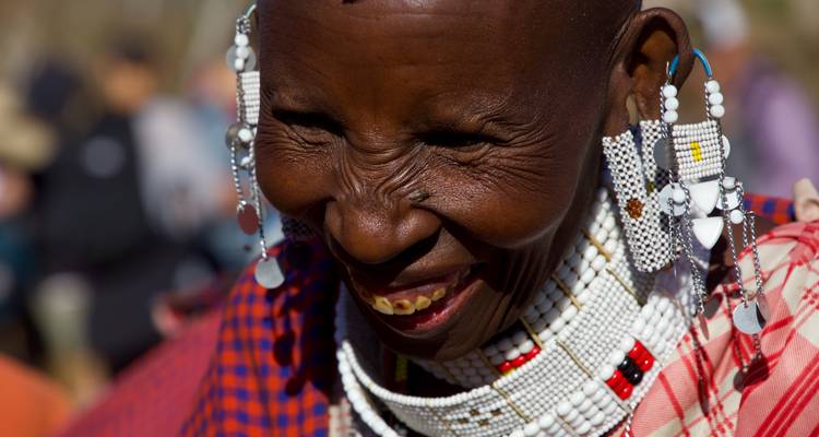 Close-up portrait of a smiling Maasai woman adorned with beads.