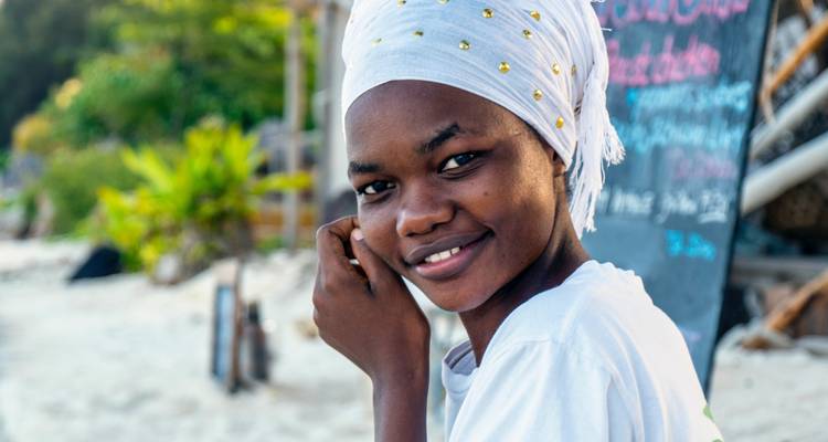Young woman smiling with a towel wrapped around her head.