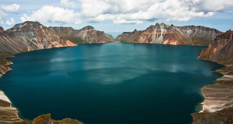 Een groot, kalm meer omringd door bergachtig terrein.