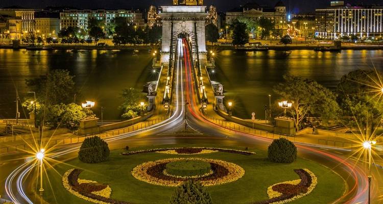 Night view of Budapest’s Chain Bridge with light trails leading to the illuminated castle across the Danube.