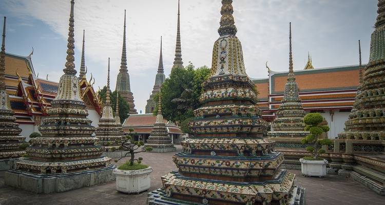 Cour de temple avec des stupas colorés à étages et des décorations complexes.