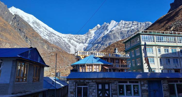 Dorf in einer bergigen Region mit schneebedeckten Gipfeln.