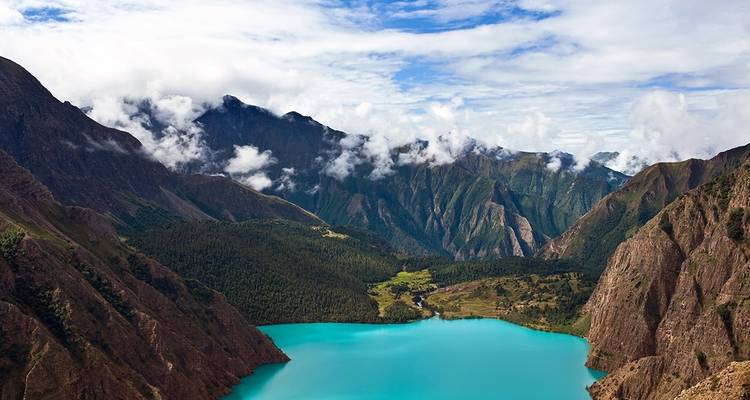 Malerischer Blick auf einen türkisfarbenen See, der von Bergen umgeben ist.