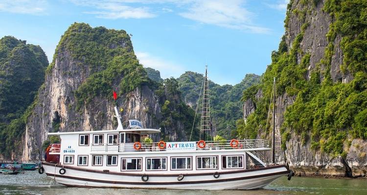 Bateau touristique naviguant parmi les karsts calcaires.