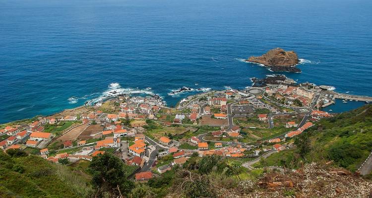 Vue aérienne d'un établissement côtier avec des falaises environnantes.