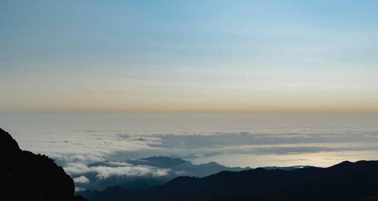 Vue mystique du coucher de soleil au-dessus des nuages et des montagnes.