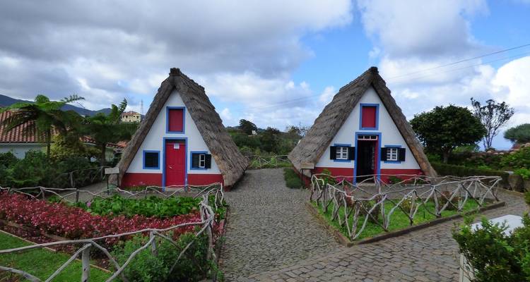 The text you provided is already in English, but it contains a French word. Here's the French translation:
**Charmantes maisons au toit de chaume dans le village de Santana.**
Note: "Santana" remains the same as it's a proper noun (place name).