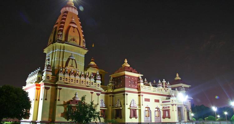 Tempel, der gegen einen Nachthimmel erleuchtet ist und kunstvolle Verzierungen zur Schau stellt.